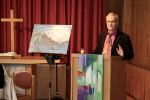Kirchengemeinderatsvorsitzender Heiner Scholz mit dem Gemälde "die Welle" als Geschenk für Pfarrerin Beck